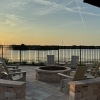 outdoor fire pit with seating and a lake in the background